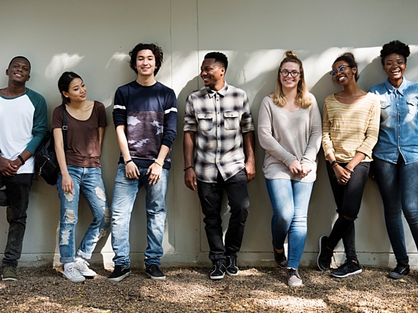 group of teenagers standing against a wall